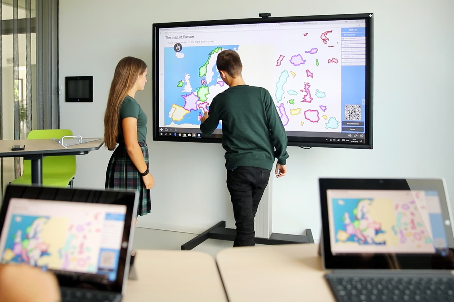 dos personas utilizando una pantalla táctil digital interactiva i3 technologies